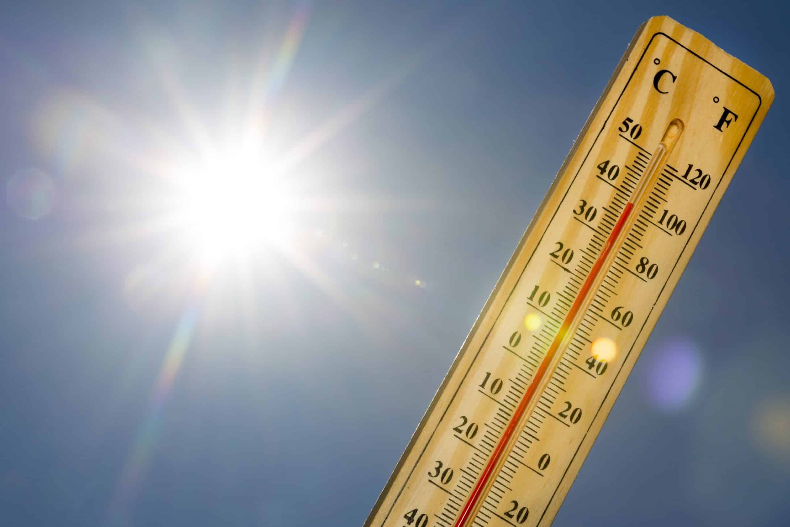 Thermometer under hot sun indicating high temperature.