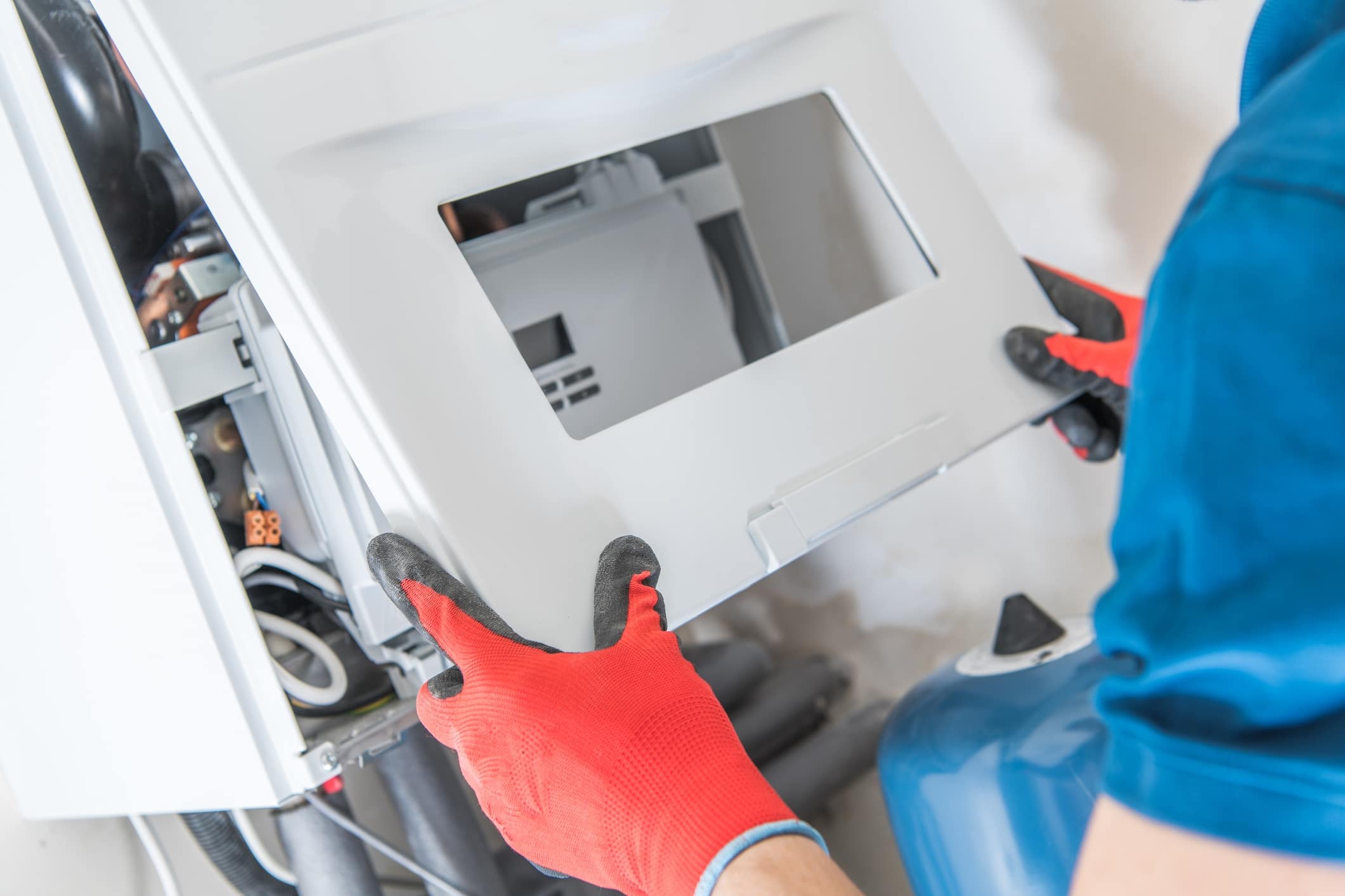 Technician opening a boiler panel for inspection.
