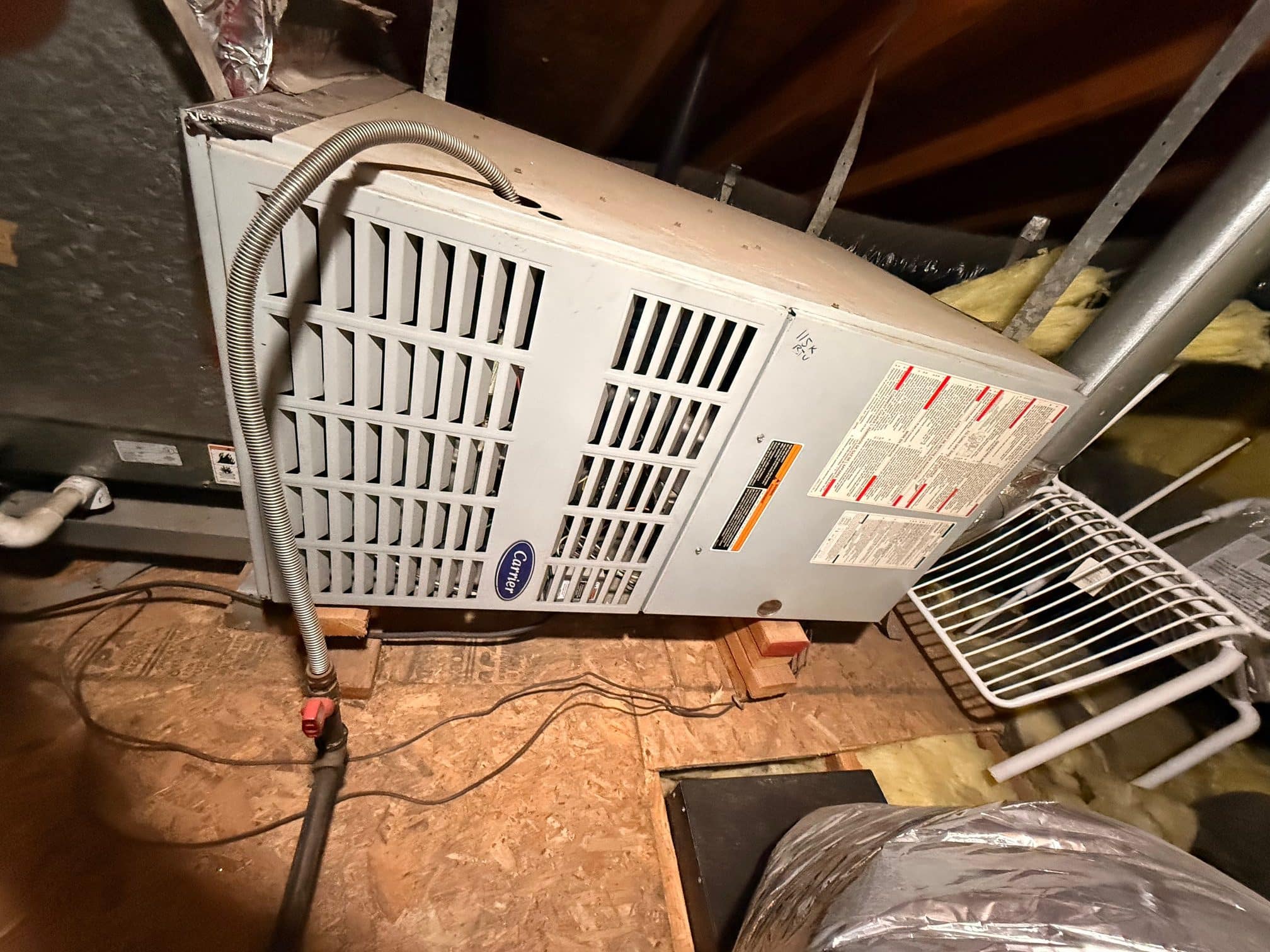 Basement heater unit with exposed pipes and wires